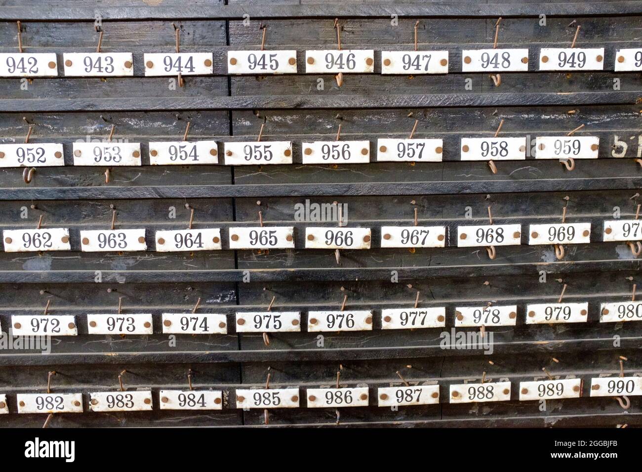 Ganci numerati in la lampisterie (sala lampada) al Saint-Etienne Mine Museum, Francia Foto Stock