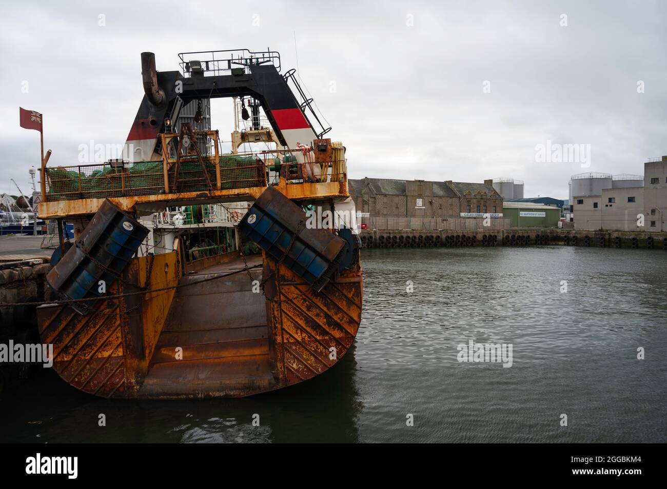 Peschereccio da traino arrugginito nel porto di Peterhead, Scozia nord-orientale. Presa dalla parte posteriore del peschereccio da traino. Mare a lato. Foto Stock