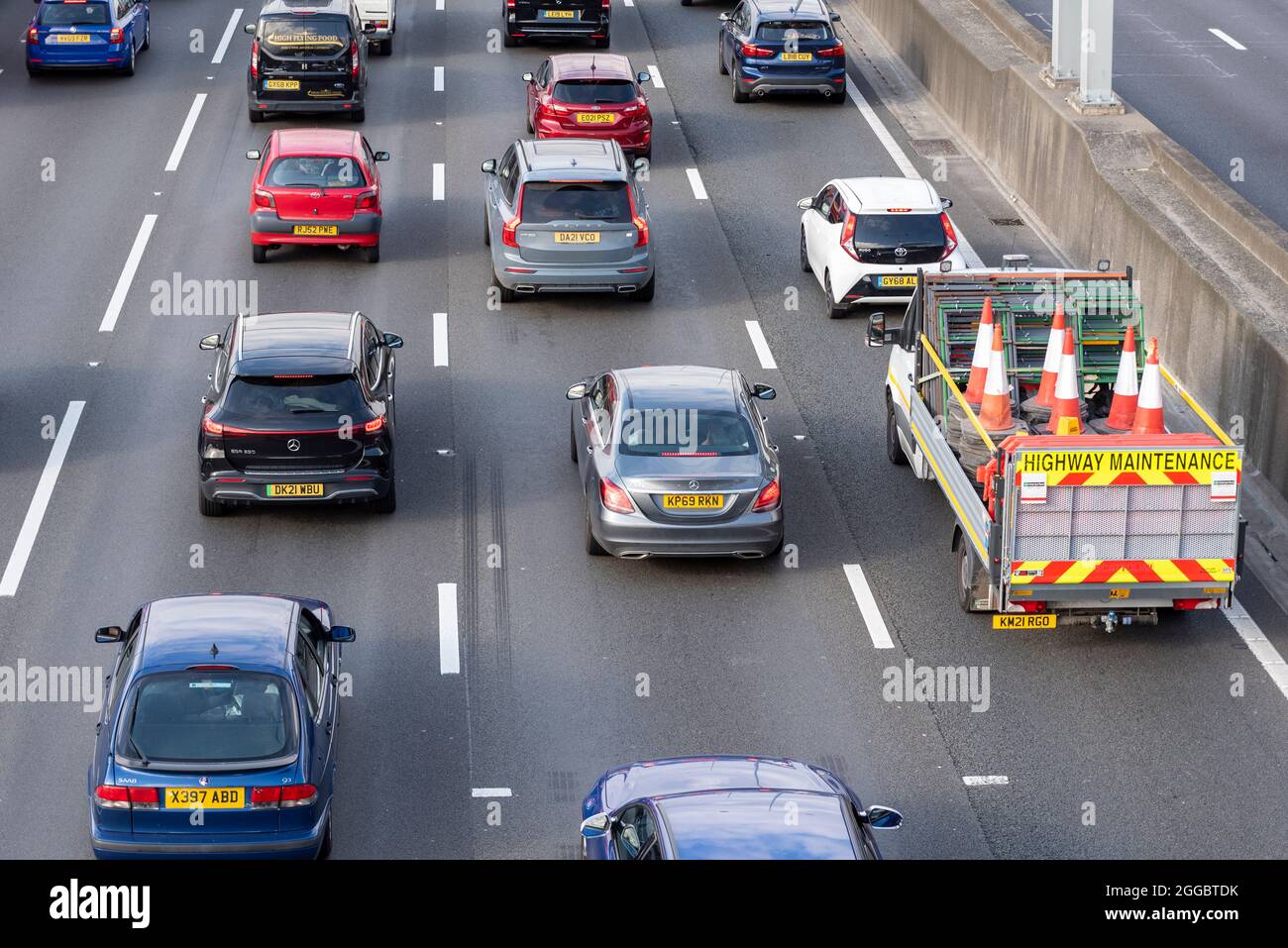 Sezione dell'autostrada M25 a Longford vicino all'aeroporto di Heathrow, Regno Unito, affollata di traffico durante un weekend estivo di agosto per le festività. Manutenzione autostrada, coni Foto Stock