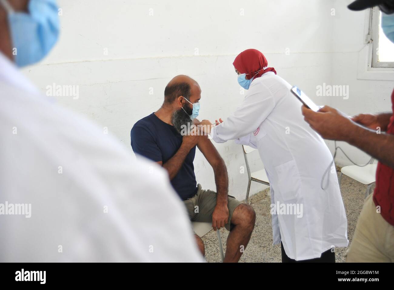 Un uomo riceve una dose di Pfizer-BioNTech durante una campagna di massa per vaccinare le persone contro la malattia di Covid-19 e ridurre il rischio di infezione. Più di 460,000 persone vaccinate durante il terzo giorno nazionale di vaccinazione di massa contro il coronavirus, secondo i risultati del terzo giorno nazionale di vaccinazione di massa contro il coronavirus, 467,631 persone hanno avuto la loro prima dose di vaccino. Il 29 agosto 2021 a Bizerete, Tunisia.(foto di Hasan Mrad / Eyepix Group) Foto Stock