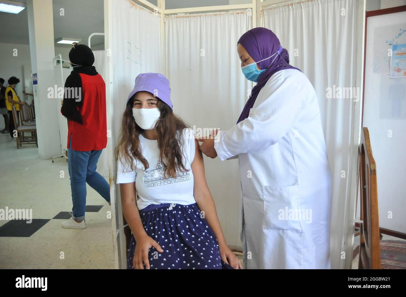 Una ragazza riceve una dose di Pfizer-BioNTech durante una campagna di massa per vaccinare le persone contro la malattia di Covid-19 e ridurre il rischio di infezione. Più di 460,000 persone vaccinate durante il terzo giorno nazionale di vaccinazione di massa contro il coronavirus, secondo i risultati del terzo giorno nazionale di vaccinazione di massa contro il coronavirus, 467,631 persone hanno avuto la loro prima dose di vaccino. Il 29 agosto 2021 a Bizerete, Tunisia.(foto di Hasan Mrad / Eyepix Group) Foto Stock