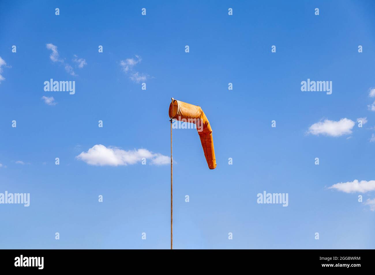 Calzino a vento che punta la posizione del vento. Calzino in arancione con cielo blu sullo sfondo, noto anche come 'Biruta de Vento' in portoghese. Foto Stock