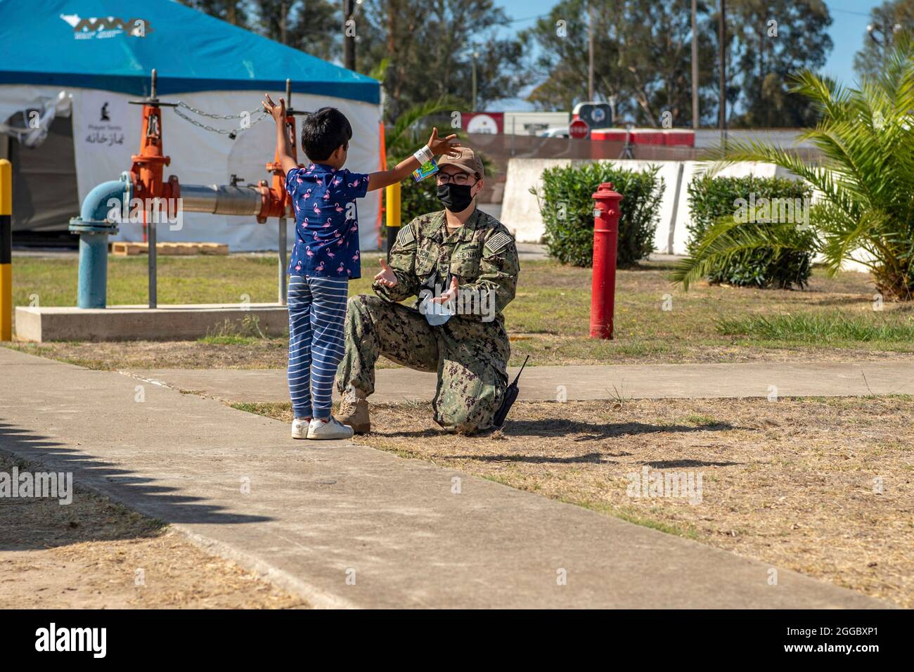 Rota, Spagna. 29 agosto 2021. Un marinaio della Marina degli Stati Uniti gioca con un bambino afghano evacuato da Kabul alla base aerea navale Rota il 29 agosto 2021 a Rota, Spagna. NAS Rota fornisce alloggio temporaneo per gli sfollati dall'Afghanistan come parte dell'operazione Allees Refuge. Credit: Planetpix/Alamy Live News Foto Stock