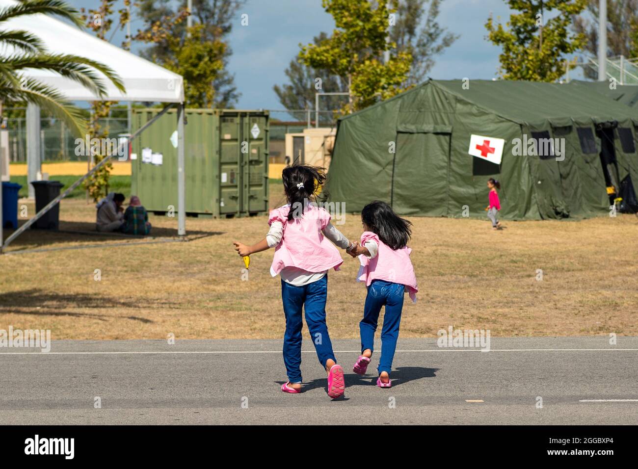 Rota, Spagna. 29 agosto 2021. Due bambini afghani evacuati da Kabul alla base aeronavale di Rota corrono intorno nella zona di alloggiamento temporanea 29 agosto 2021 a Rota, Spagna. NAS Rota fornisce alloggio temporaneo per gli sfollati dall'Afghanistan come parte dell'operazione Allees Refuge. Credit: Planetpix/Alamy Live News Foto Stock