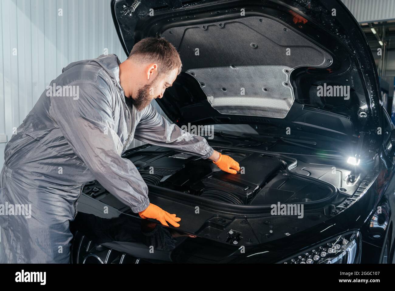 Auto Mechanic controllo auto con cofano aperto in officina auto riparazione Foto Stock