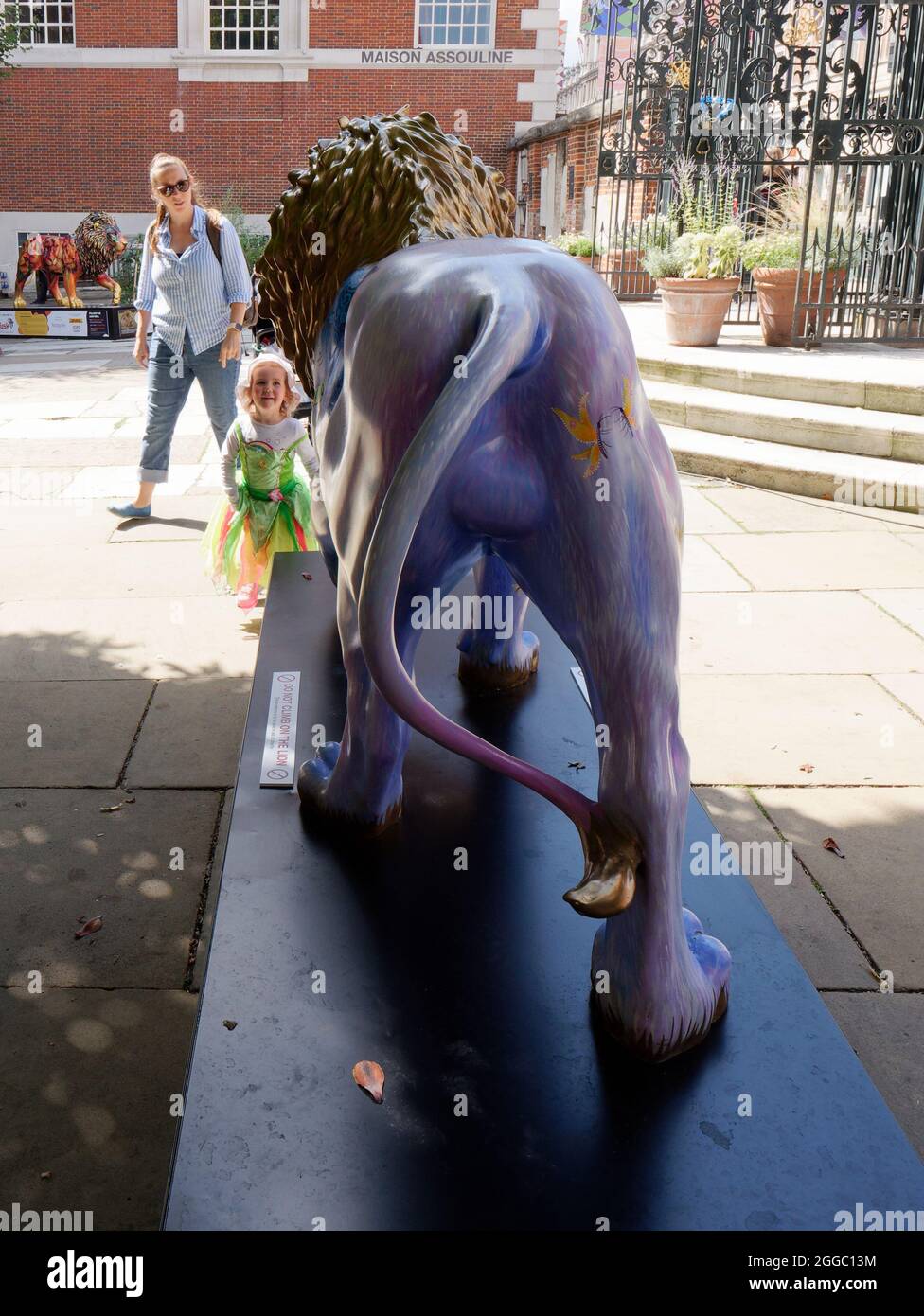 Il London Pride Tusk Lion Trail, una giovane ragazza si avvicina a Worker di Helen Downie AKA non specializzato in St James Churchyard Foto Stock