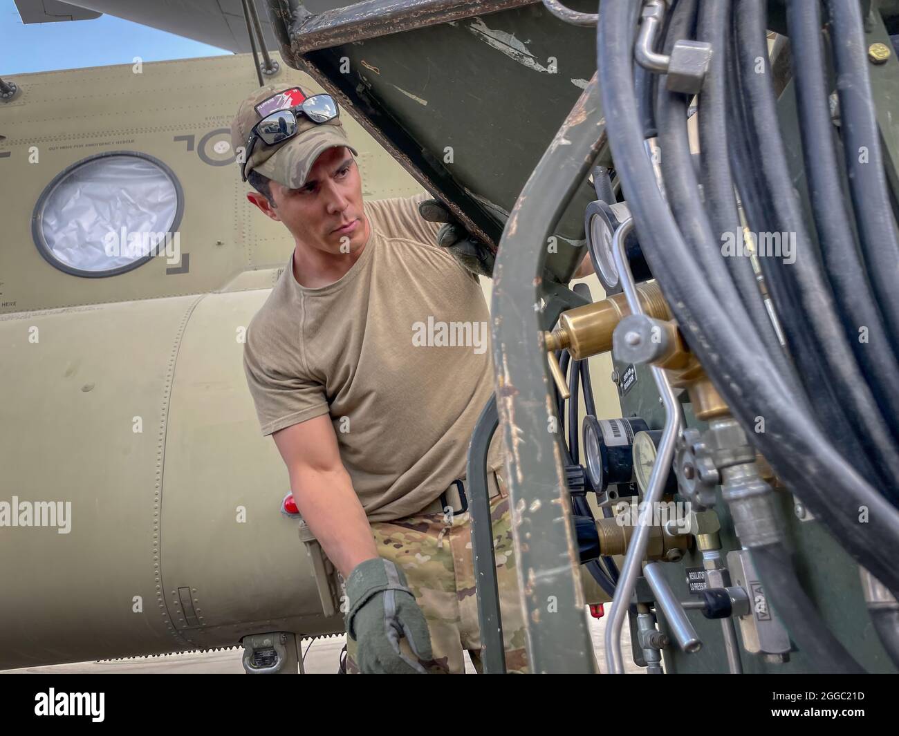 Un paratrooper assegnato alla 82a brigata dell'aviazione di combattimento, 82a Divisione Airborne prepara un CH-47 Chinook per caricare su una forza aerea statunitense C-17 Globemaster III all'aeroporto internazionale Hamid Karzai di Kabul, Afghanistan, agosto 28. Il Chinook. È uno dei pezzi di equipaggiamento che ritornano negli Stati Uniti quando la missione militare in Afghanistan si conclude Foto Stock