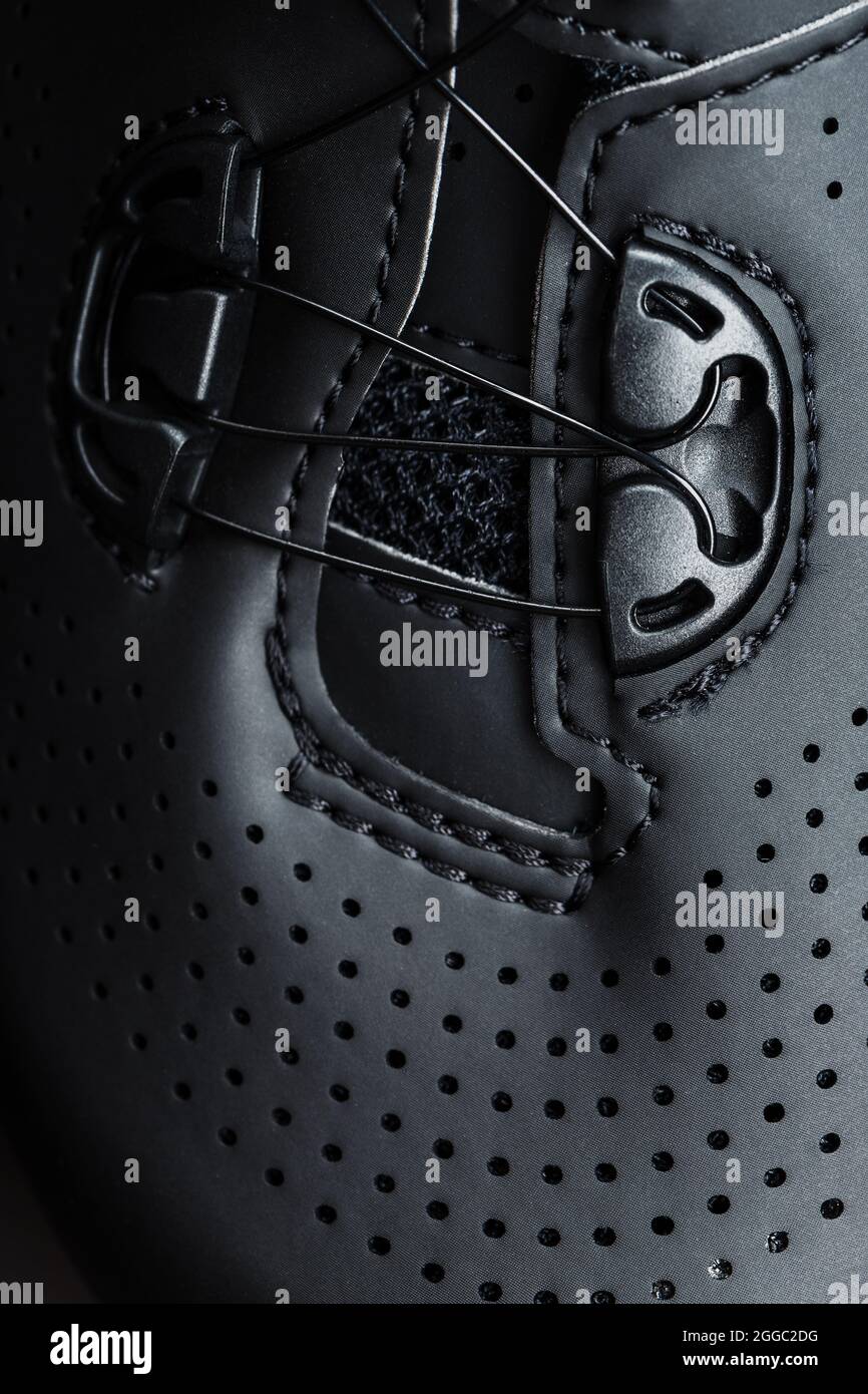 Scarpe sportive in pelle nera traforata con chiave scura. Primo piano Foto Stock