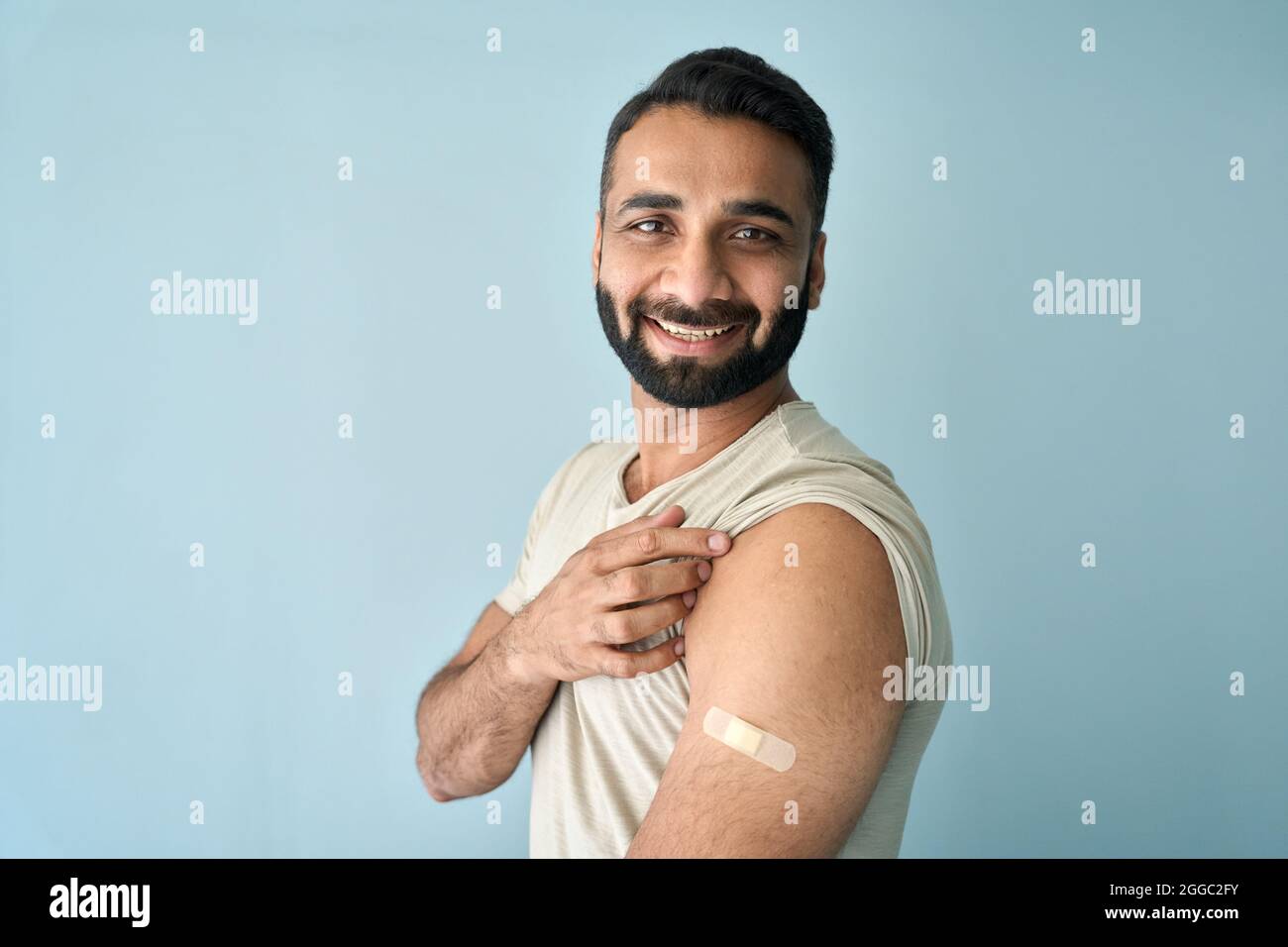 Ritratto del giovane indiano dopo il vaccino covid19 con gesso sulla spalla. Foto Stock