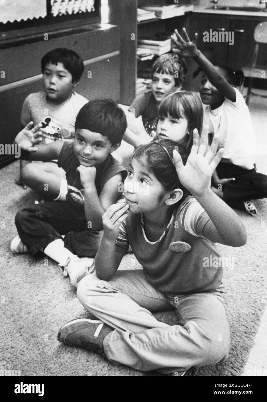 Austin Texas USA, 1990 circa: Gli studenti delle scuole elementari ispaniche si siedono sul pavimento durante la storia in una classe di istruzione bilingue. ©Bob Daemmrich Foto Stock
