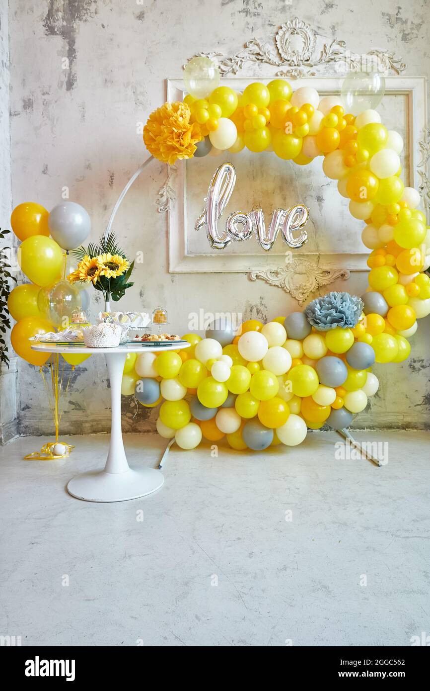 Zona foto di palloncini gialli e grigi. La festa è decorata con palloncini. Immagine verticale. Foto Stock