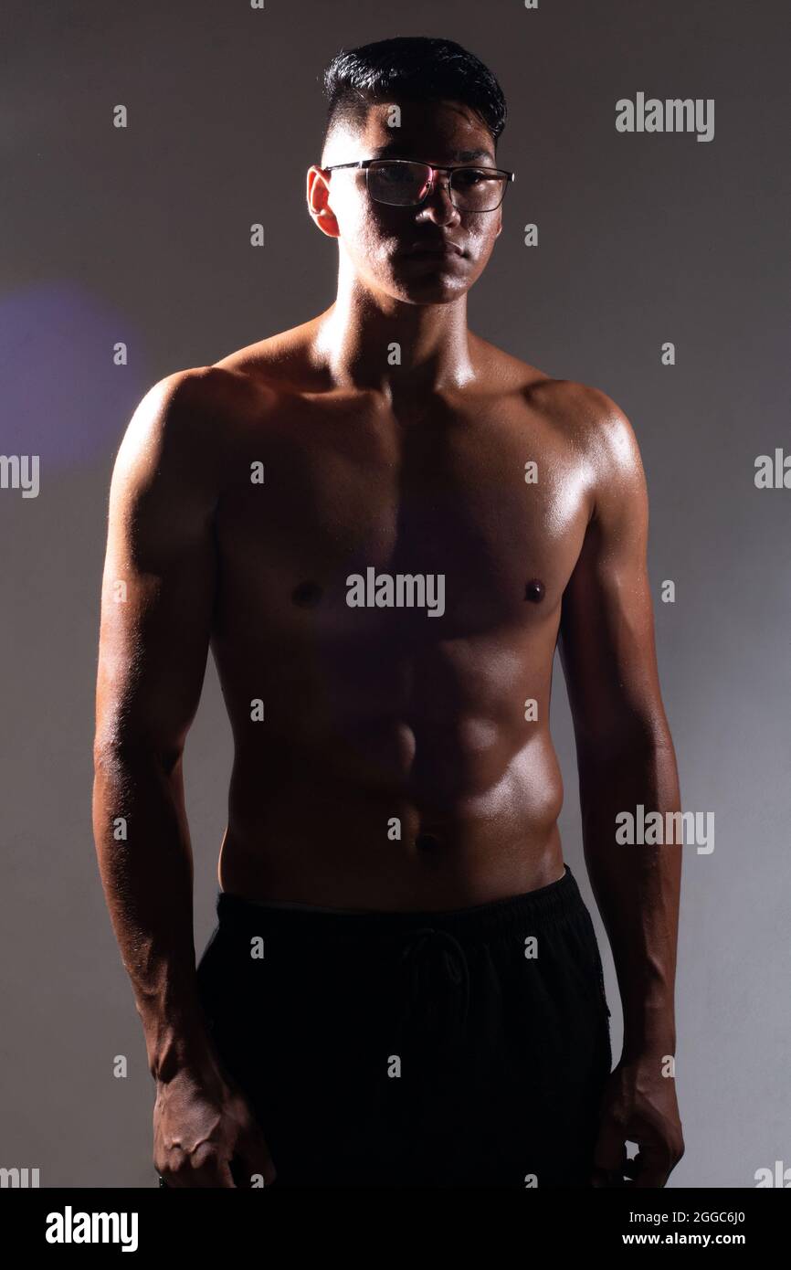 l'uomo latino che si posa su sfondo scuro senza camicia. l'uomo muscolare Foto Stock