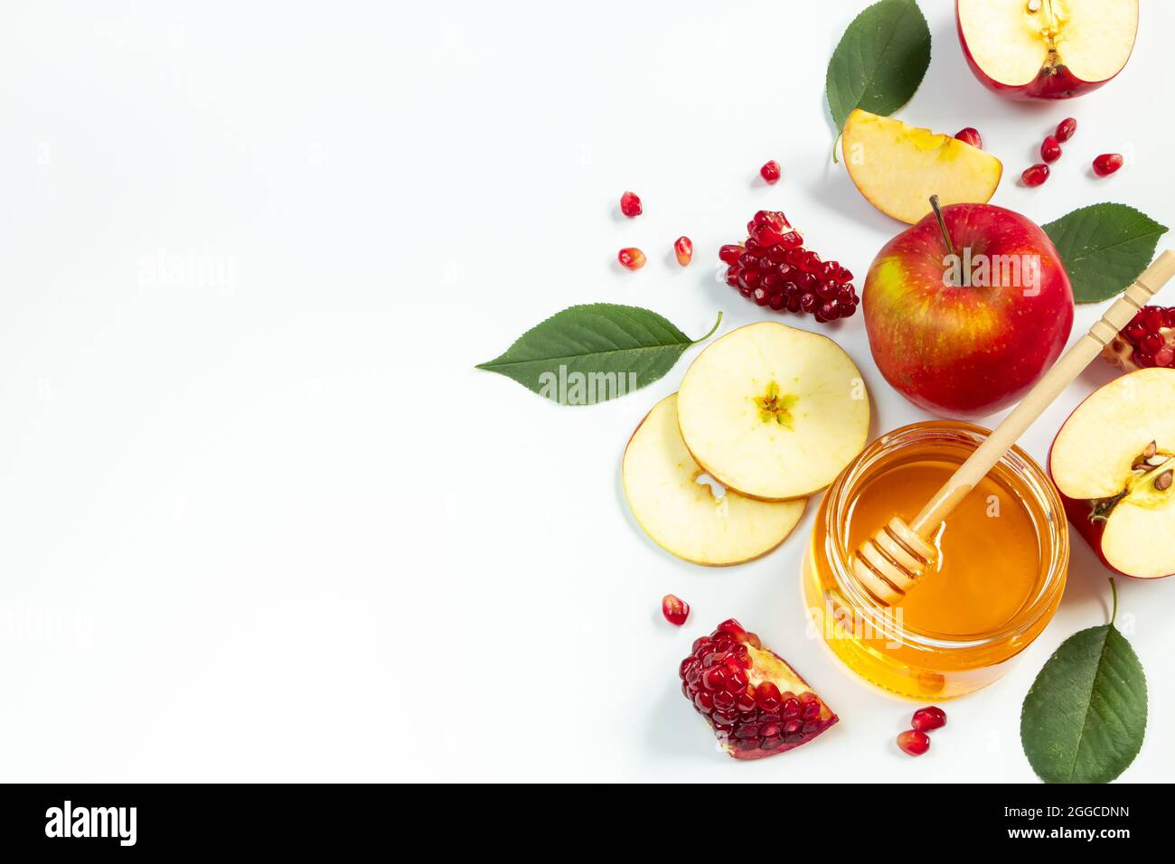 Concetto di tradizionale vacanza ebraica di Rosh Hashanah. Anno nuovo. Melagrane, miele e mele su sfondo bianco. Inserire il testo. Foto Stock