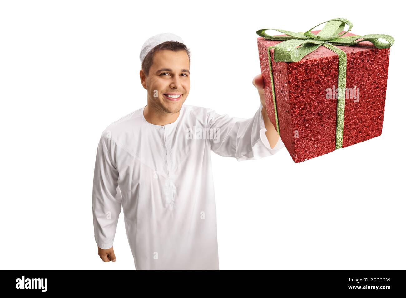 Giovane uomo in abiti bianchi di etnia che tiene una scatola rossa presente isolato su sfondo bianco Foto Stock