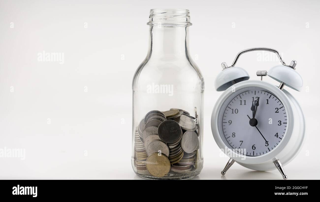 Concetto Business finanza e Shopping vendita monete in vaso con sveglia bianca Business oggetti isolati su sfondo bianco Foto Stock