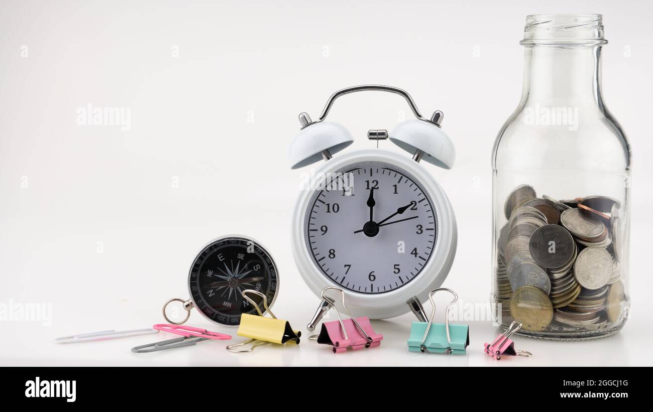 Concetto Business finanza e Shopping vendita monete in vaso con sveglia bianca Business oggetti isolati su sfondo bianco Foto Stock