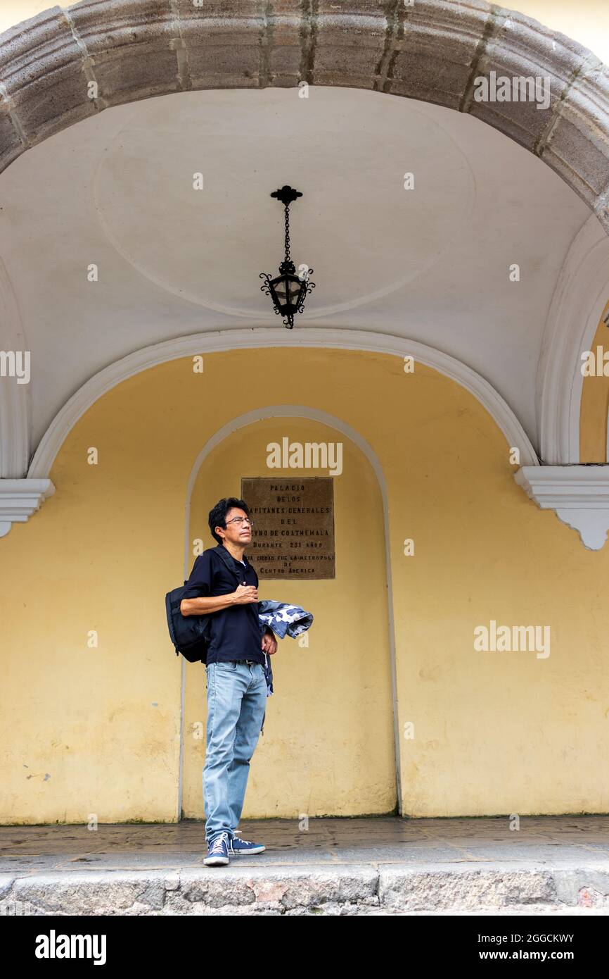 il turista si erge di fronte all'edificio coloniale Foto Stock