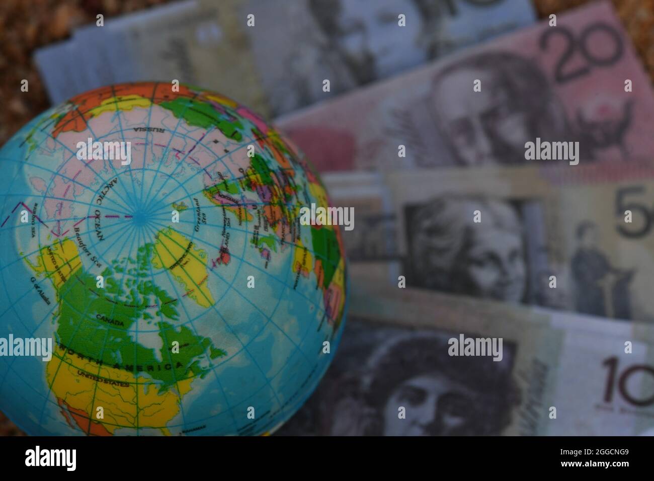 Mappa del globo terrestre dell'Artico, seduta su un gruppo di banconote in natura. Foto Stock