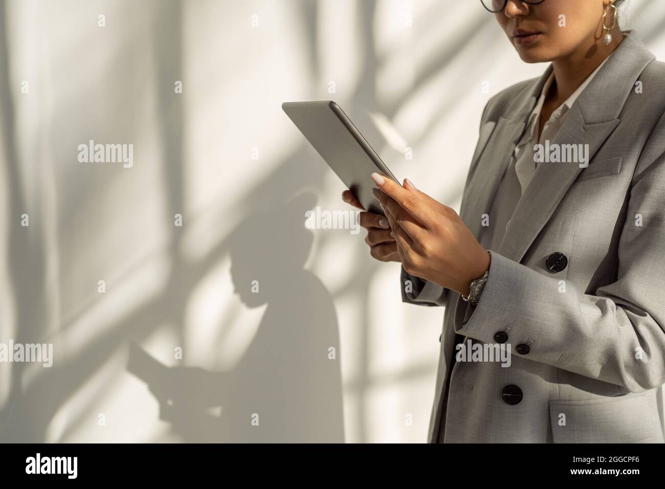 Metà della sezione di una giovane donna d'affari con tablet digitale che comunica in chat video Foto Stock