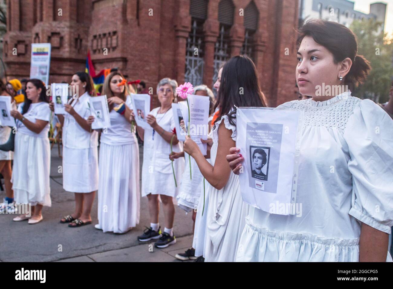 Durante la manifestazione, i manifestanti hanno fotografato le vittime dell'esercito colombiano.circa 200 persone hanno dimostrato di fronte all'Arc de Triomf di Barcellona contro le 6402 uccisioni extragiudiziali commesse dall'esercito nel contesto del conflitto armato colombiano, un fenomeno noto come "falsi positivi". La manifestazione si è svolta in occasione della Giornata Internazionale delle vittime della sparizione forzata, commemorata ogni 30 agosto e alla quale ha partecipato Ricardo 'Profe', una delle prime linee di difesa, nelle proteste anti-governative in Colombia. Foto Stock