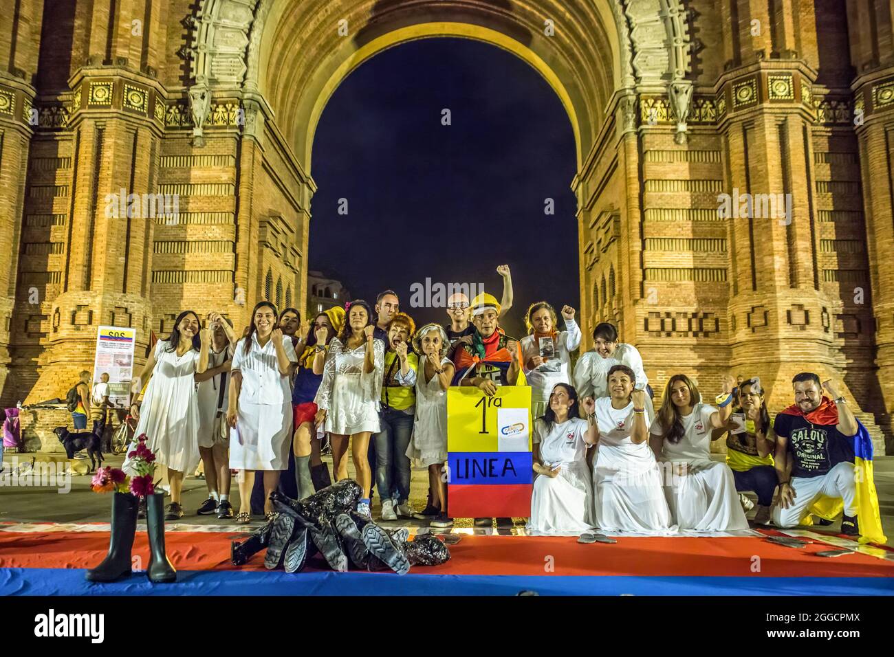 Barcellona, Spagna. 30 ago 2021. La prima linea di difesa nelle proteste anti-governative in Colombia, Ricardo 'Profe' si pone con i manifestanti mentre reggono una bandiera durante la dimostrazione.circa 200 persone hanno dimostrato di fronte all'Arc de Triomf di Barcellona contro le 6402 uccisioni extragiudiziali commesse dall'esercito nel contesto del conflitto armato colombiano, un fenomeno noto come "falsi positivi". Credit: Sipa USA/Alamy Live News Foto Stock