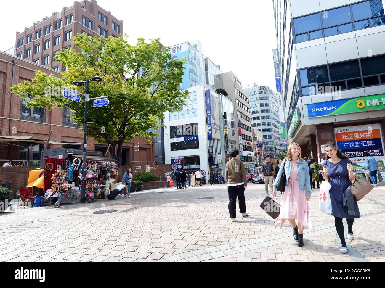 Donne caucasiche che fanno shopping nel vibrante quartiere dello shopping di Myeongdong a Seoul, Corea del Sud. Foto Stock