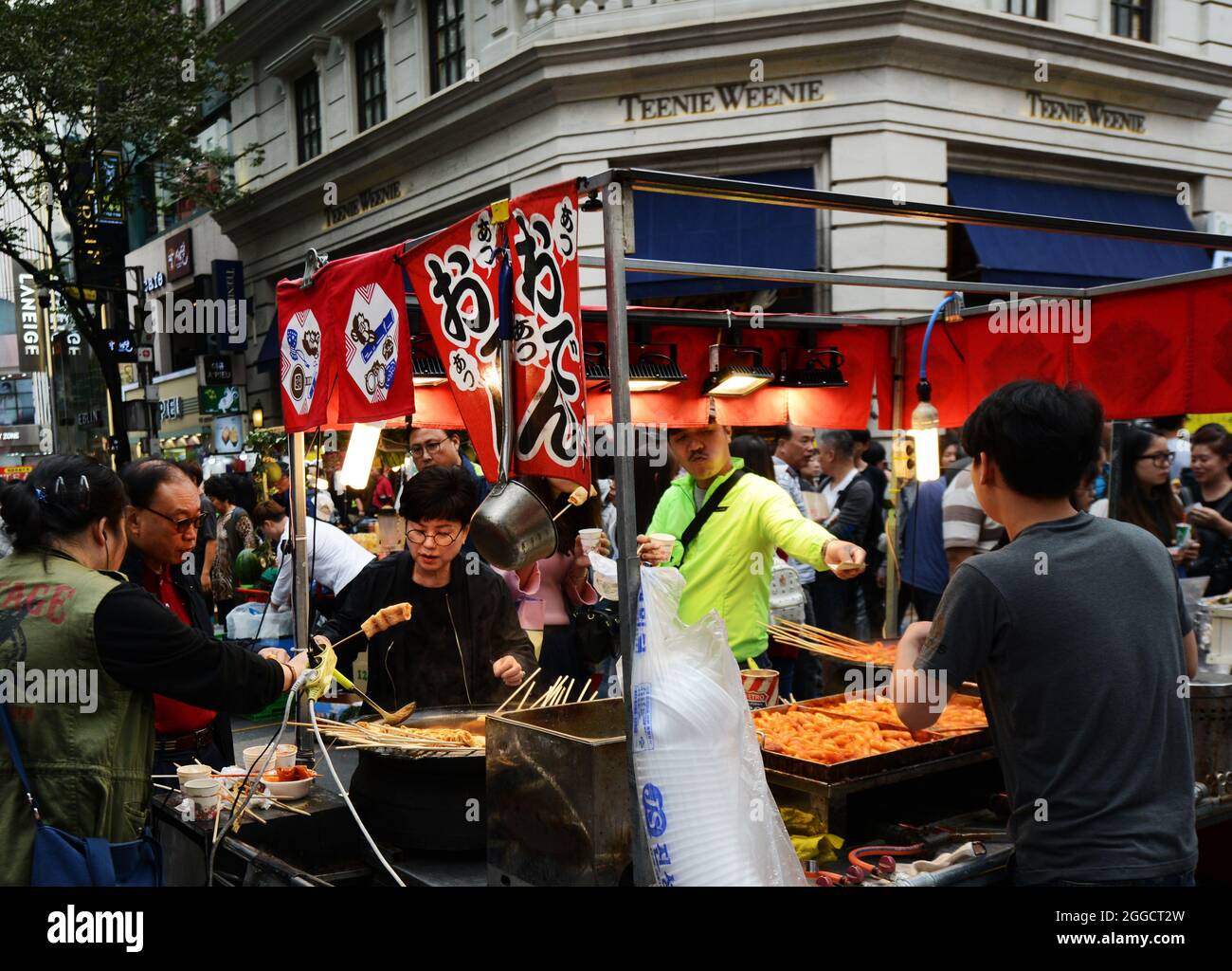 Venditori di cibo di strada nel popolare quartiere dello shopping di Myeongdong, Seoul, Corea del Sud. Foto Stock