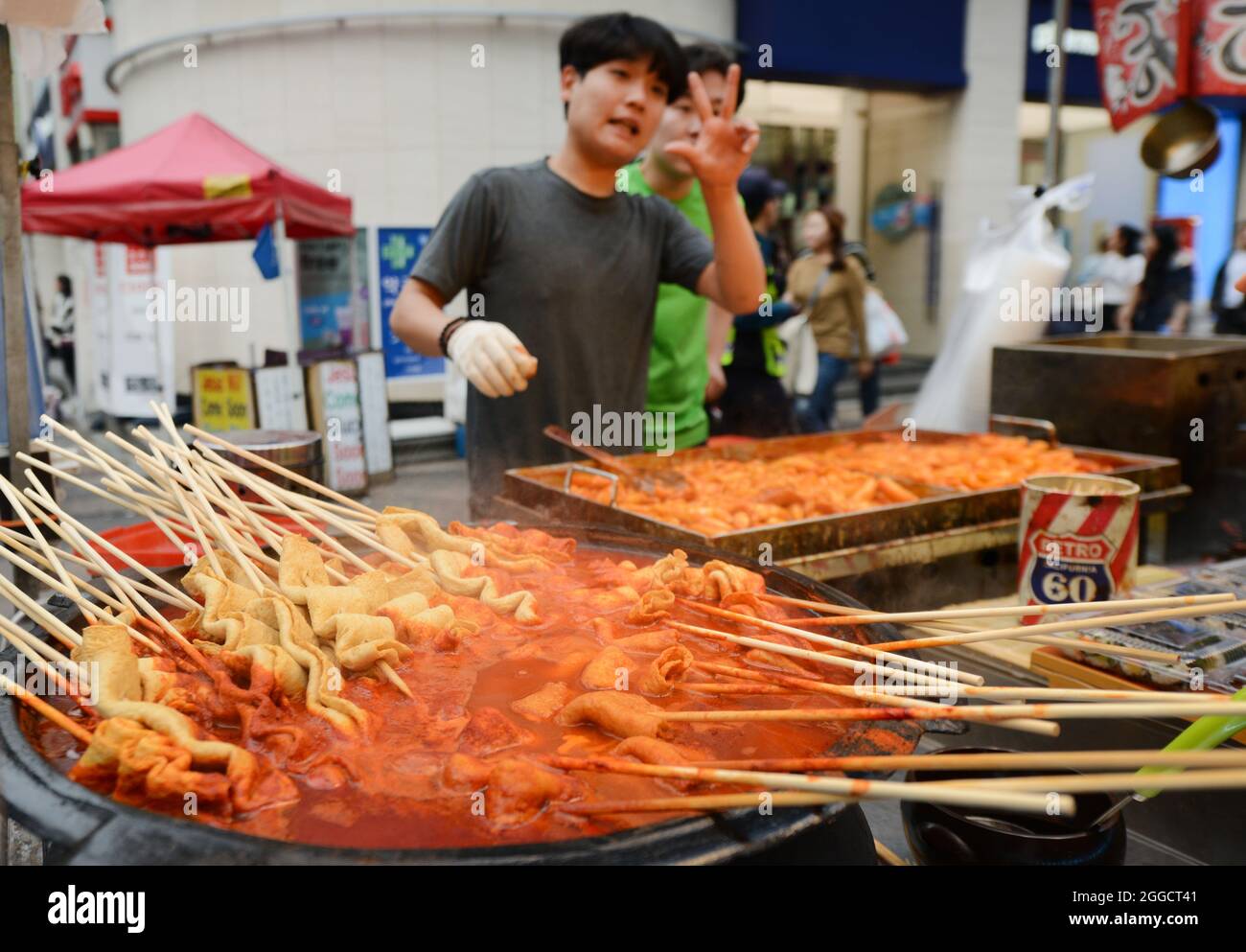 Venditori di cibo di strada nel popolare quartiere dello shopping di Myeongdong, Seoul, Corea del Sud. Foto Stock