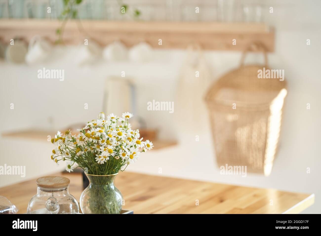 Bellissimi fiori bianchi a margherita in un vaso di vetro sul tavolo da cucina vicino alla finestra. Composizione floreale in casa, arredamento. Foto di alta qualità Foto Stock