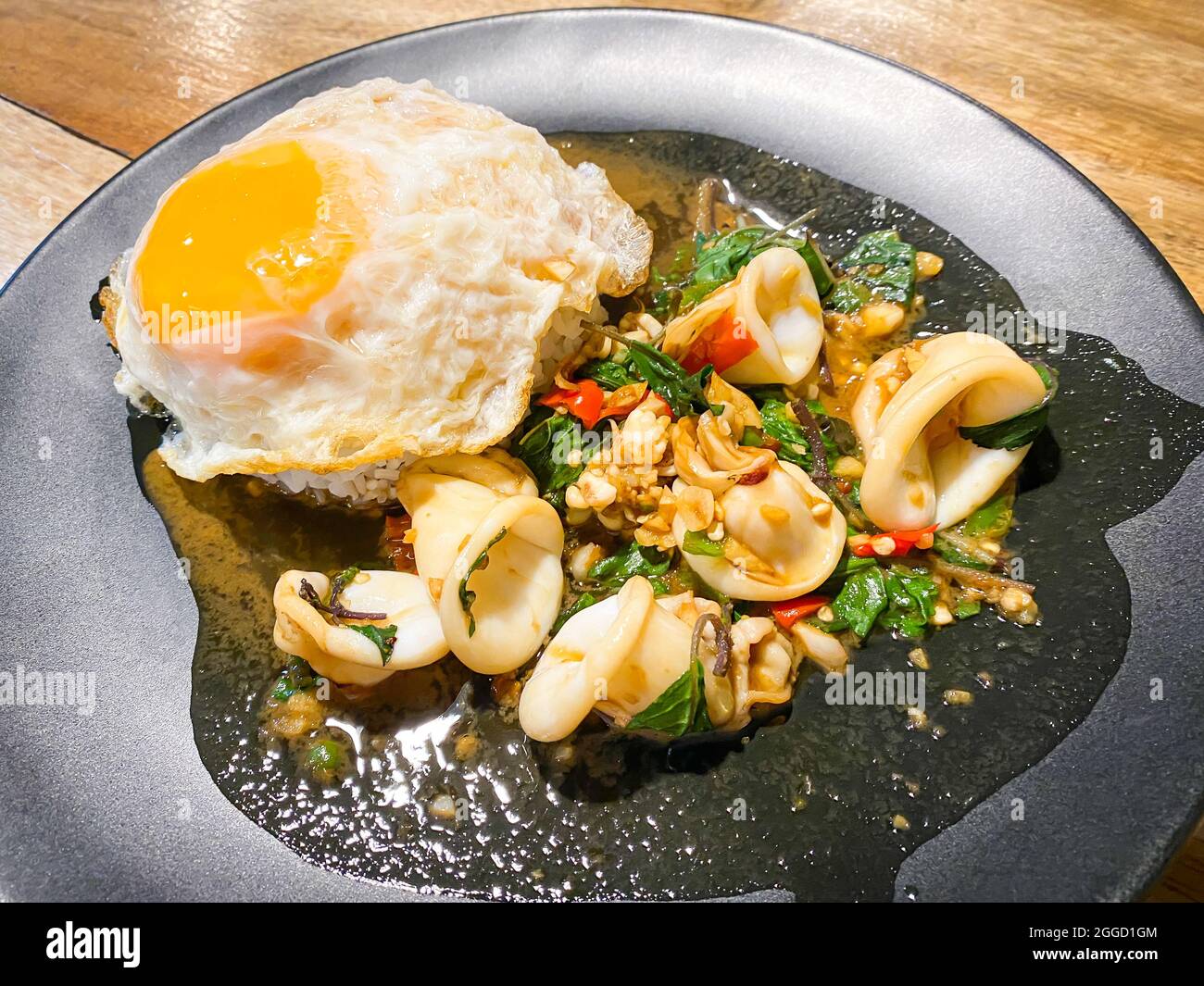 Riso condito con calamari fritti e basilico con uova fritte Foto Stock