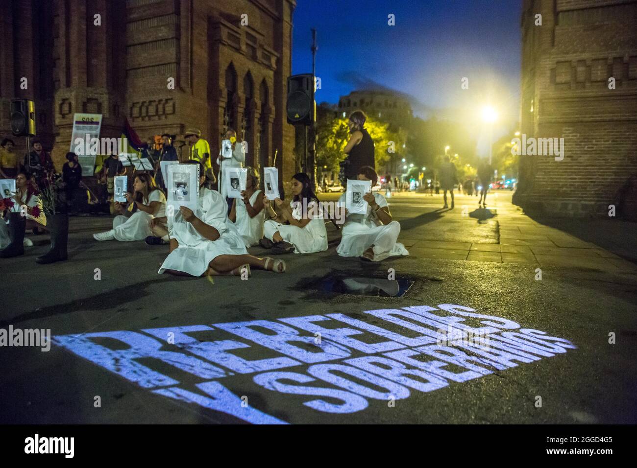 Barcellona, Catalogna, Spagna. 30 ago 2021. I manifestanti sono visti di fronte alla proiezione con cui dice, ribelli e sovrani.circa 200 persone hanno dimostrato di fronte all'Arc de Triomf di Barcellona contro le 6402 uccisioni extragiudiziali commesse dall'esercito nel contesto del conflitto armato colombiano, un fenomeno noto come ''falsi positivi''. La manifestazione si è svolta in occasione della Giornata Internazionale delle vittime della sparizione forzata, commemorata ogni 30 agosto e alla quale hanno partecipato Ricardo ''Profe''', una delle prime linee di difesa, in Th Foto Stock