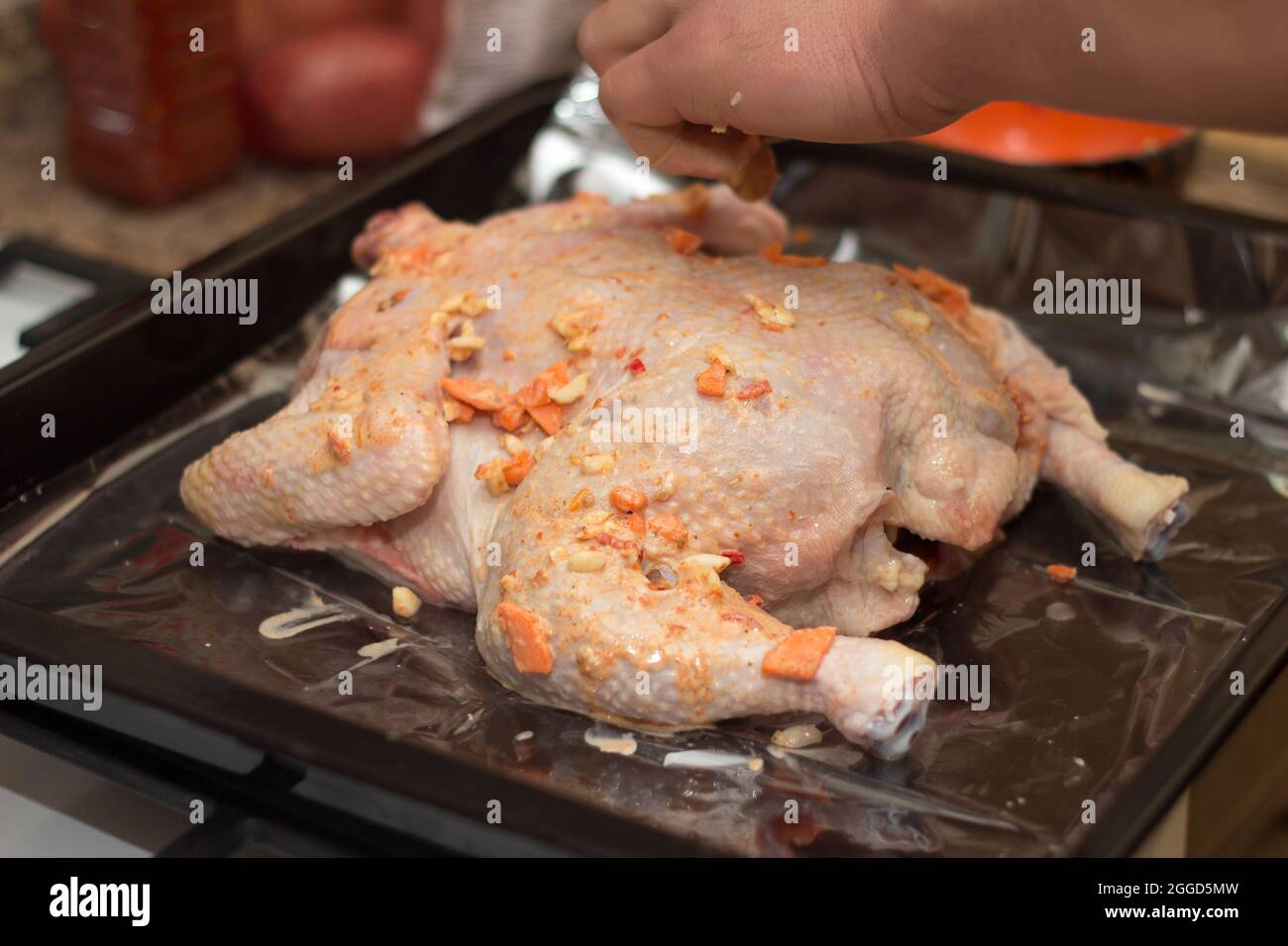 L'uomo cuoco prepara il pollo per la cottura con le spezie in forno Foto Stock