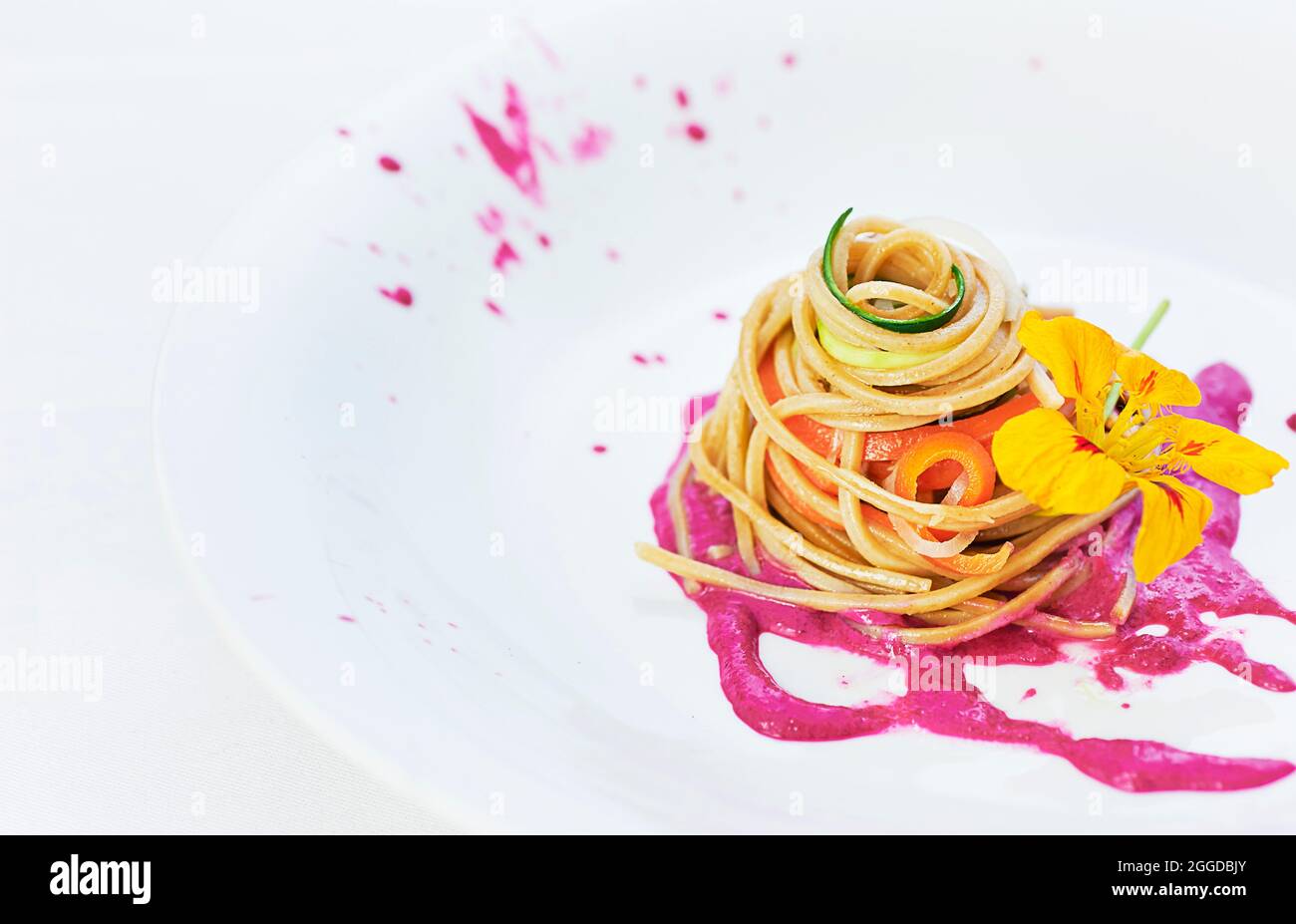 Spaghetti di pasta di grano integrale serviti con crema di barbabietole, yogurt, olio d'oliva, tahina e miso Foto Stock