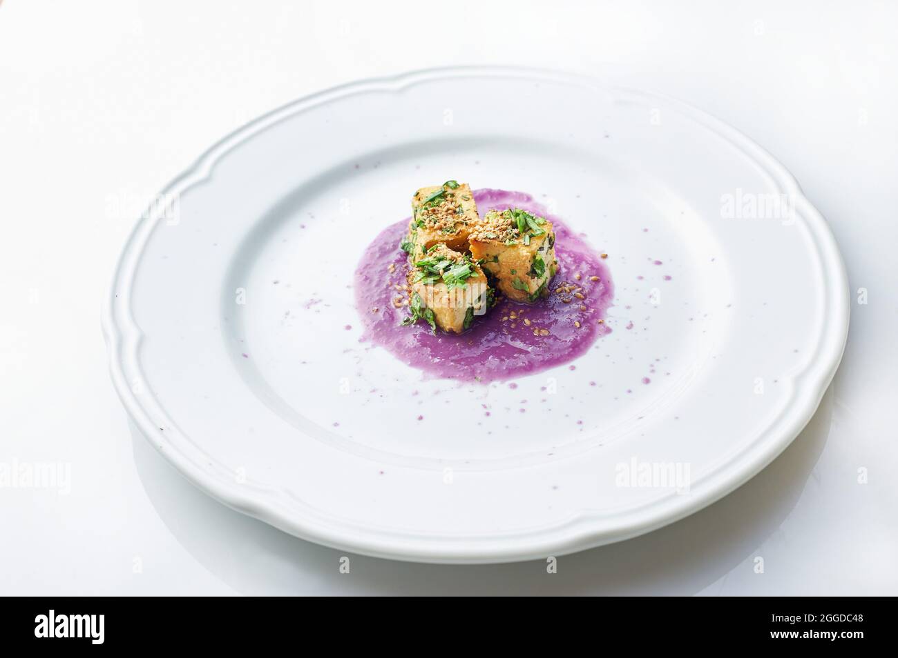 Tofu naturale saltato in padella con erba aromatica sul cavolo e crema di zenzero addensato con farina di riso. Foto Stock