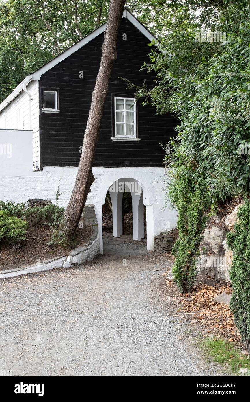 Arch costruito sotto una casa che fornisce l'accesso al sentiero costiero a Portmerion Village, un'attrazione turistica in stile italiano e resort nel Galles del Nord. Foto Stock