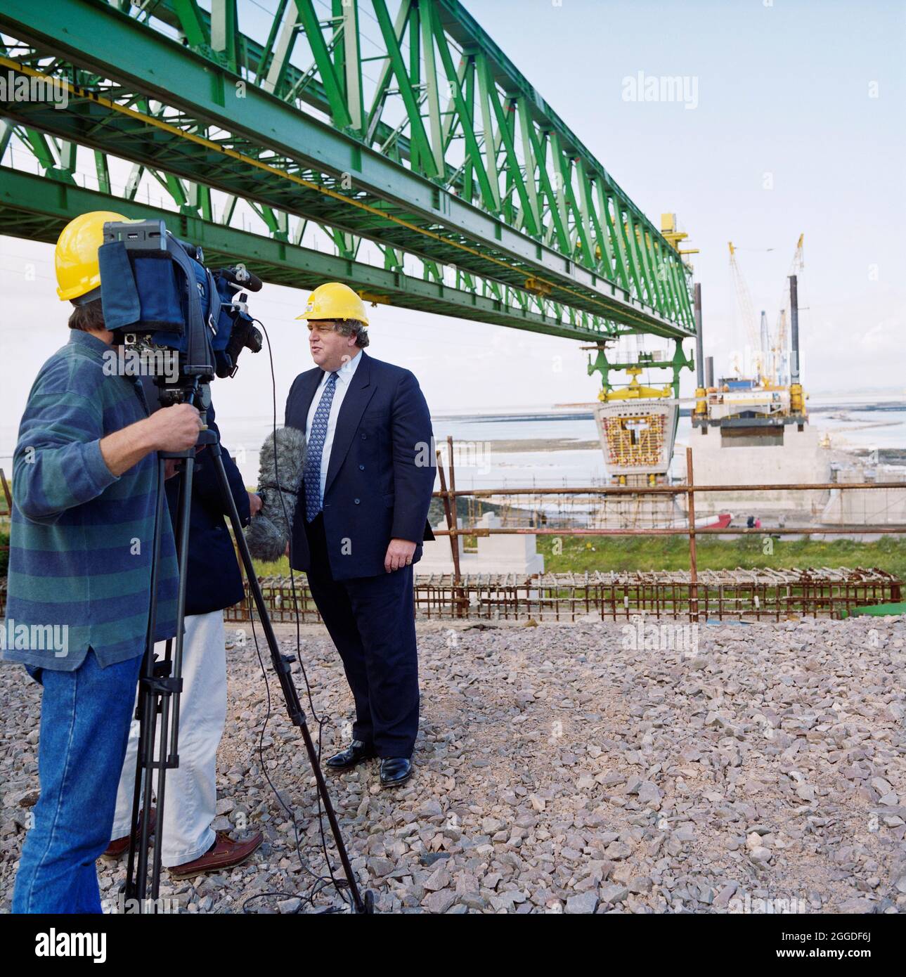 Robert Key, ministro dei Trasporti, è stato intervistato sulla macchina fotografica durante la visita al secondo cantiere Severn Crossing durante l'installazione delle prime unità ponte del ponte, con un portale di lancio appositamente progettato sopra. Il secondo Severn Crossing ha impiegato quattro anni per costruire ed è stato un progetto di ingegneria civile congiunto tra Laing Civil Engineering e la società francese GTM. I lavori sono iniziati nell'aprile 1992 e la cerimonia di apertura si è svolta il 5 giugno 1996. L'incrocio è un ponte a fune che si estende per oltre 5000 metri attraverso il fiume Severn, a 3 miglia a valle dalla Th Foto Stock