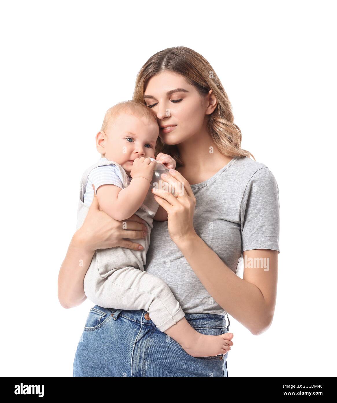 Giovane madre che dà l'acqua al suo bambino carino su sfondo bianco Foto Stock