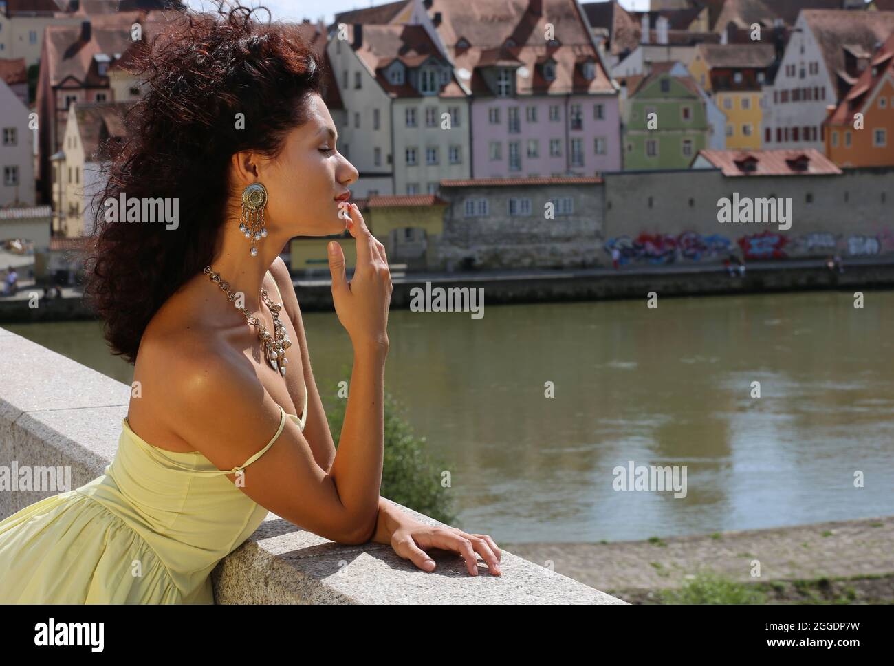 Regensburg Altstadt oder Innenstadt oder City mit schwarzhaariger Schönheit mit sinnlichen Blick und gelben Kleid. Oberpfalz, Baviera, Ratisbona. Foto Stock