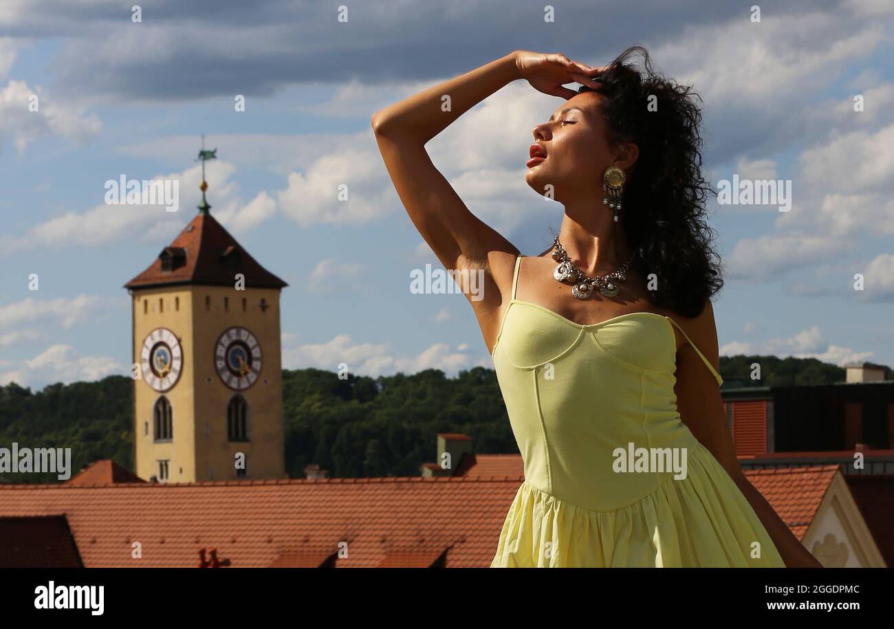 Regensburg Altstadt oder Innenstadt oder City mit schwarzhaariger Schönheit mit sinnlichen Blick und gelben Kleid. Oberpfalz, Baviera, Ratisbona. Foto Stock