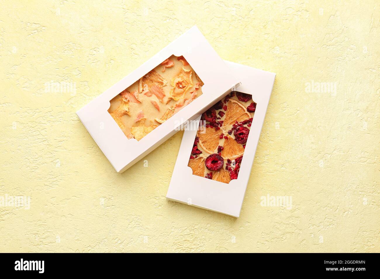Tavolette di cioccolato fatte a mano con frutta e bacche su sfondo colorato Foto Stock