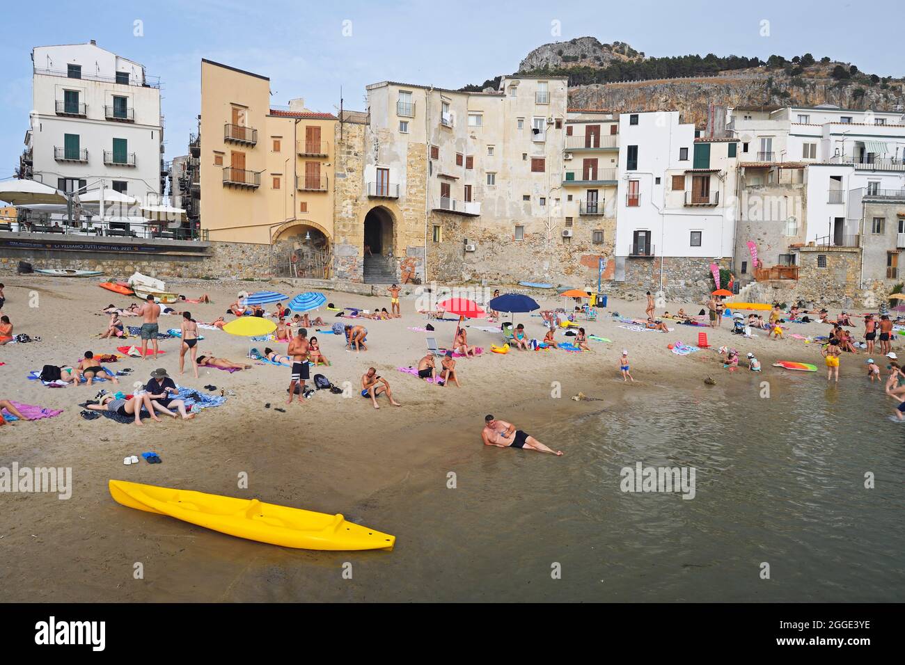 Bagnanti sulla spiaggia del centro storico, località turistica Cefalu, Sicilia, Italia Foto Stock