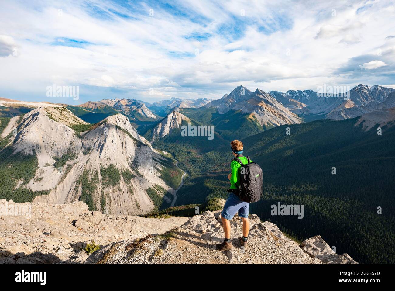 Escursionista che guarda in lontananza, paesaggio di montagna con valle del fiume e cime, cime con depositi di zolfo arancione, capovolto montagna, panoramica Foto Stock