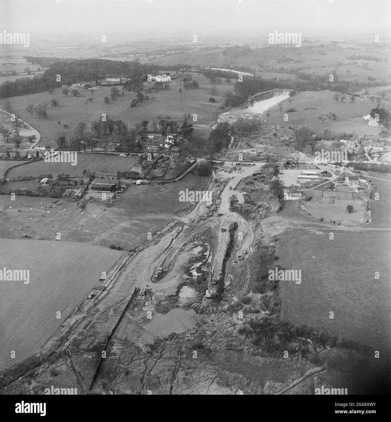 Una vista aerea della costruzione della Sezione D.1 dell'autostrada Birmingham-Preston (M6) nella zona di Little Madeley, guardando a nord e mostrando la strada A525 che passa sotto l'autostrada. I lavori sull'autostrada da Birmingham a Preston (M6), tra gli svincoli da J13 a J16 iniziarono nel giugno 1960 e furono eseguiti da John Laing Construction Ltd. La sezione D era di 7 1/2 miglia di lunghezza tra Keele e Barthomley. Foto Stock