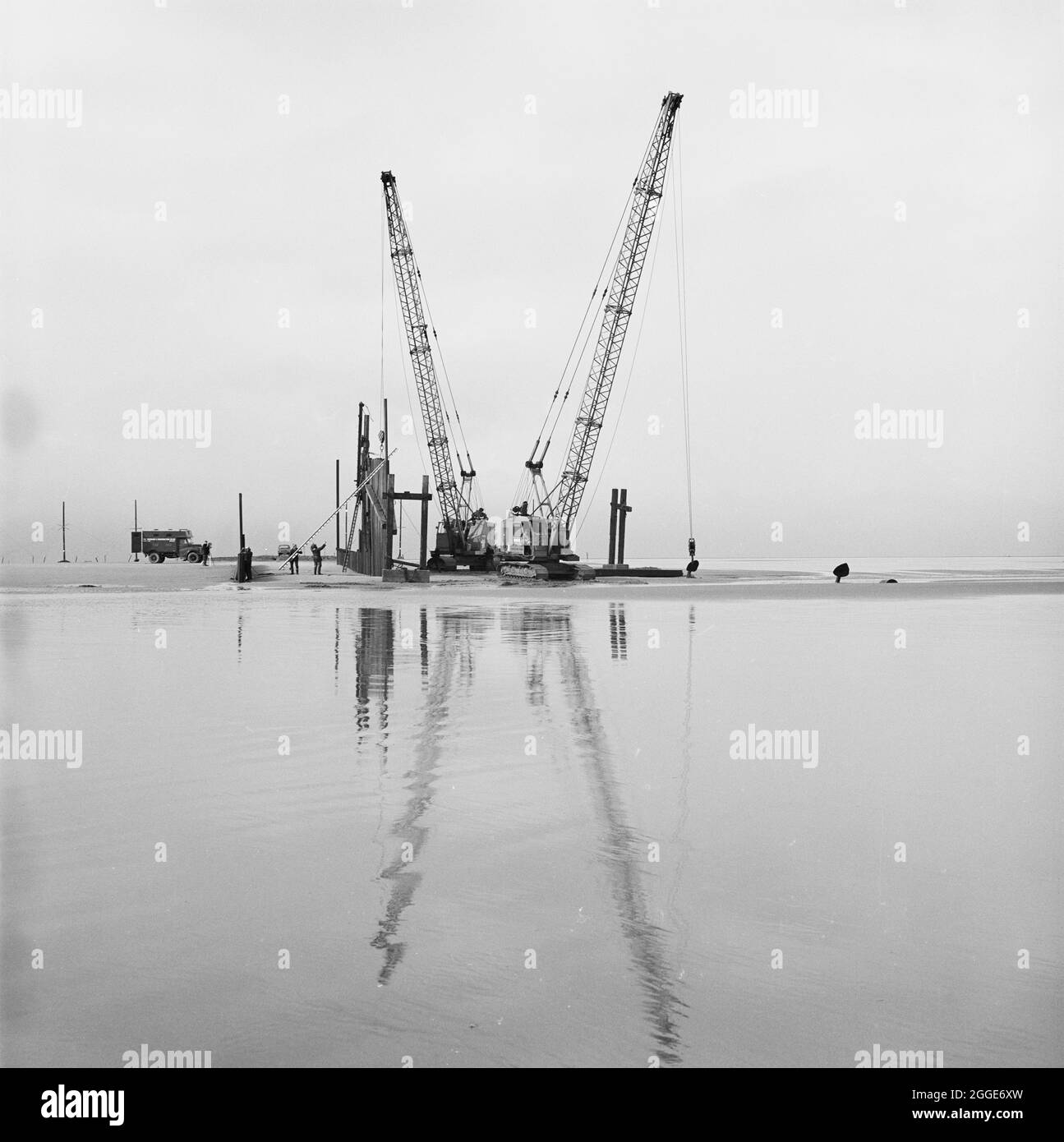 Due gru installano pile di fogli a livello medio di marea durante i lavori di ingegneria civile sulla pipeline North Coates. I lavori di ingegneria civile sul gasdotto North Coates sono stati eseguiti da Laing Pipelines insieme alle società francesi Entrposa e GTM. Più di due miglia di 36 pollici di diametro pipeline, incassato in calcestruzzo, è stato successivamente tirato fuori al mare nell'estuario di Humber. Questa fotografia è stata pubblicata nel maggio 1970 nella newsletter mensile Laing "Team Spirit". Foto Stock