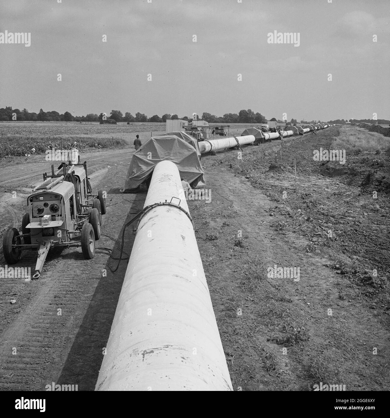Una vista del gasdotto Fens, che mostra le tettoie protettive situate in corrispondenza dei giunti lungo il tubo in cui sono state effettuate saldature secondarie. I lavori per la posa del gasdotto Fens sono iniziati nel giugno 1967 e sono stati una joint venture tra Laing Civil Engineering e le società francesi Entrepose e Grands Travaux de Marseille (GTM) per il Consiglio del gas. Oltre 600 uomini hanno lavorato al progetto per posare tubi in acciaio di diametro 36 pollici a partire da West Winch a Norfolk e fino a dove si è collegato con il prossimo contratto a Woodcroft Castle a Cambridgeshire. Il gasdotto attraversava quattro fiumi e numerose dighe e fossati. Foto Stock