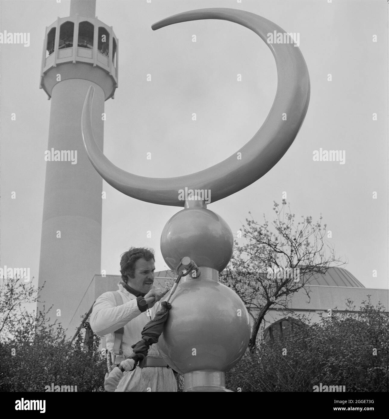 La Moschea Centrale di Londra e il Centro Culturale Islamico, Park Road, Regent's Park, City of Westminster, Greater London Authority, 15/03/1977. Vista ravvicinata di un uomo con la mezzaluna al di fuori della moschea centrale di Londra, prima che fosse sollevato sul tetto a cupola della sala di preghiera. La finale è stata realizzata in cemento rinforzato con fibra di vetro (GRC) nel Northamptonshire, e dipinta nel Galles del Sud per dare una finitura color oro. Foto Stock