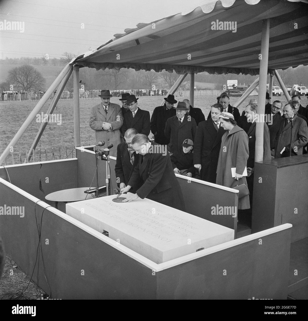 Harold Watkinson, il ministro dei Trasporti e dell'aviazione civile, ha posto un sigillo nella lastra di inaugurazione concreta per la prima sezione dell'autostrada Londra-Yorkshire a Slip End vicino a Luton. Sir Owen Williams, il Consulting Engineer, si trova accanto a Harold Watkinson. Alla cerimonia di inaugurazione, Harold Watkinson ha anche avviato un claxon corno come segnale per i conducenti delle macchine da scavo di iniziare il lavoro. Alla cerimonia hanno partecipato Sir John William Laing e Sir John Maurice Laing. Tra gli ospiti vi erano rappresentanti delle cinque contee attraverso le quali la strada passerà. Foto Stock