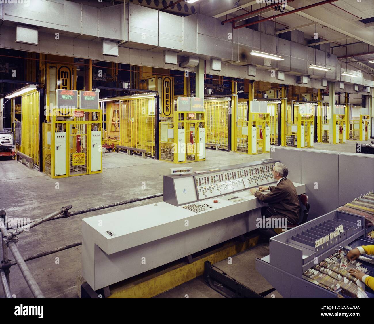 Un uomo seduto in un banco di controllo della Ford Motor Company Works, che opera una fila di gru Munck. Questa immagine è stata catalogata come parte del Breaking New Ground Project in collaborazione con il John Laing Charitable Trust nel 2019-20. Foto Stock