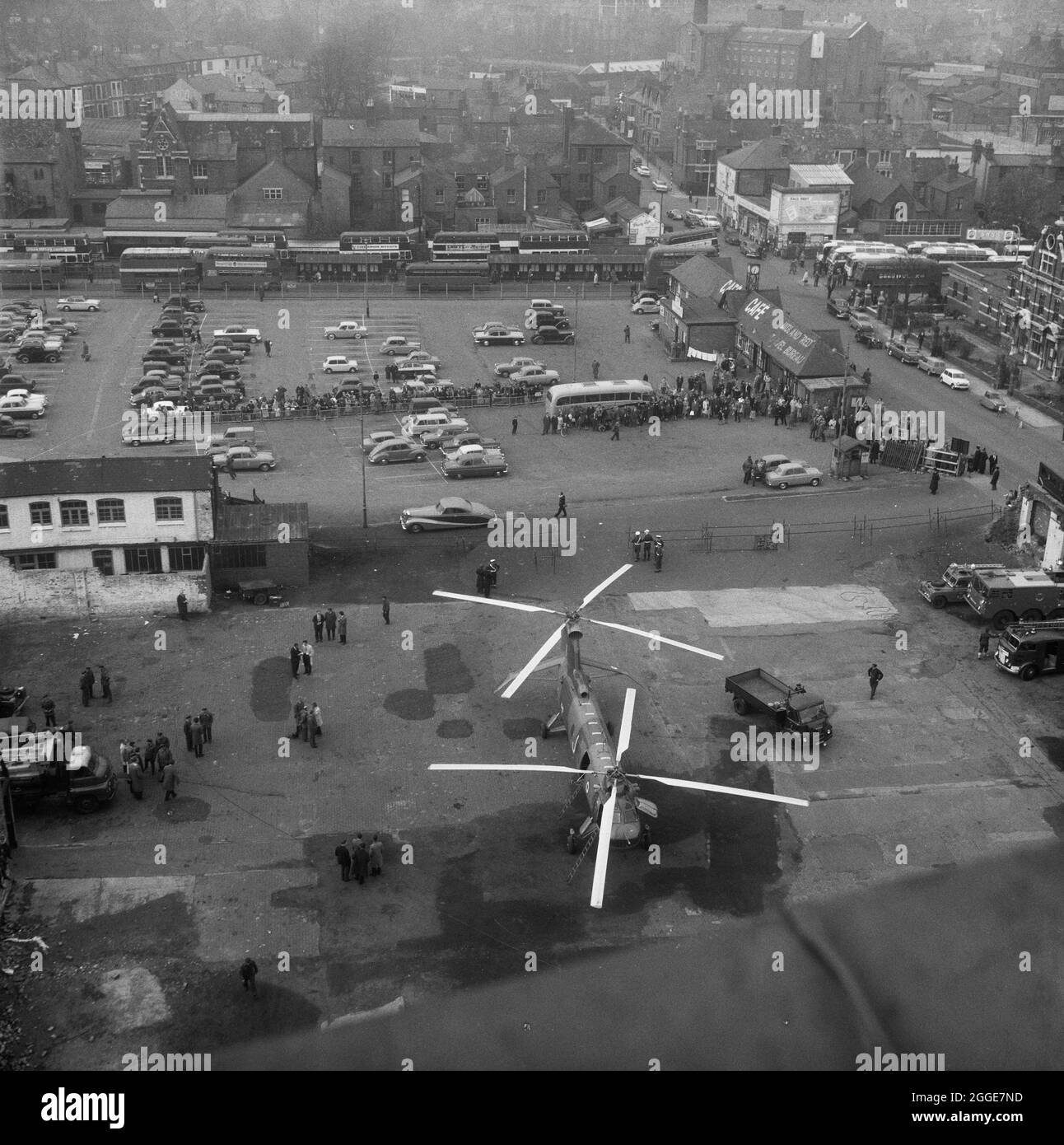 Guardando dal tetto della Cattedrale di Coventry verso un elicottero Belvedere RAF parcheggiato sul tarmac sottostante, mostrando una folla riunita per guardare alla stazione degli autobus Pool Meadow a nord della cattedrale. La fotografia è stata scattata durante l'operazione Rich Man, un progetto congiunto che coinvolse il personale dell'Aeronautica reale e il personale di Laing. Questo ha coinvolto un elicottero belvedere RAF che si è issato per posizionare la guglia di bronzo da 80 piedi sulla nuova cattedrale. La parte dell'operazione di abbassamento della traversa di 1/2 tonnellate che si trova sulla sommità della guglia doveva essere posticipata a causa delle condizioni di vento. Foto Stock