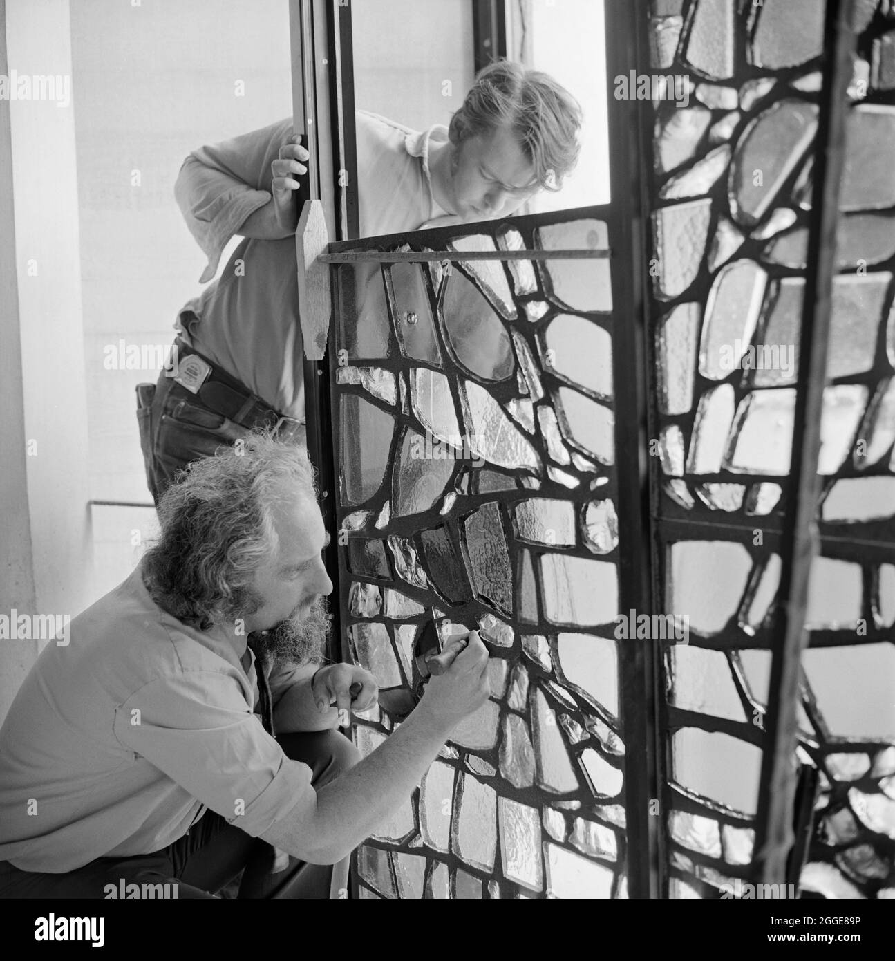 L'artista Henry Haig e il suo assistente, installando una delle vetrate colorate nel nartece alla Cattedrale di Clifton. Henry Haig (1930-2007) fu un artista astratto e pittore noto per la sua opera in vetro colorato. Le vetrate colorate nel nartece della Cattedrale di Clifton sono fatte da 8000 pezzi di vetro e i disegni raffigurano la Pentecoste e la giubilazione. Foto Stock